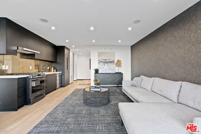 living room featuring light wood-type flooring and sink