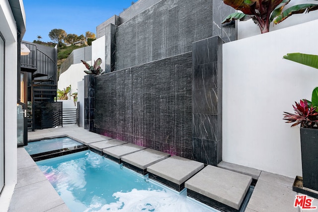 view of pool with an in ground hot tub