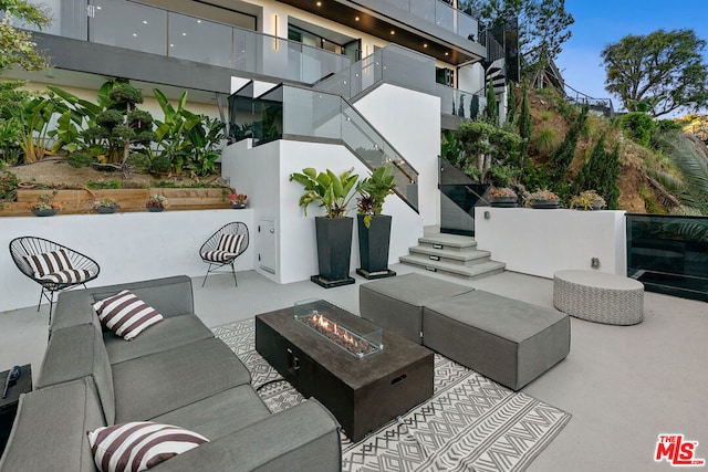 view of patio with an outdoor living space with a fire pit