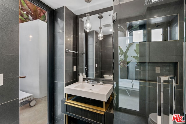 bathroom with toilet, tile walls, and vanity