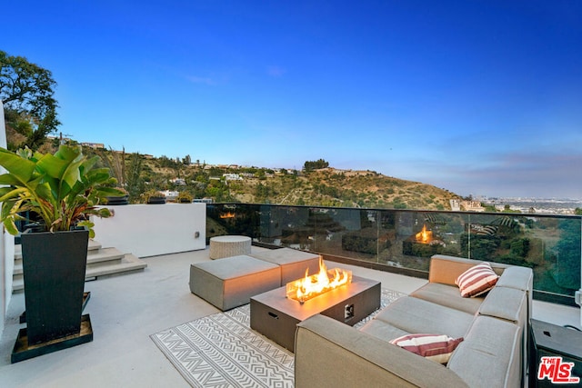 patio terrace at dusk with an outdoor living space with a fire pit