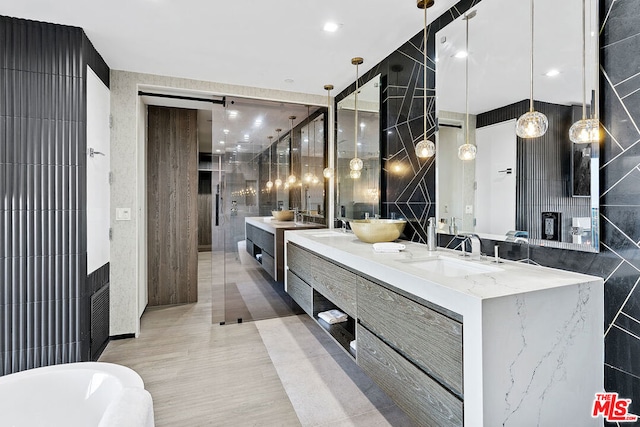 bathroom with a washtub, tile walls, and vanity