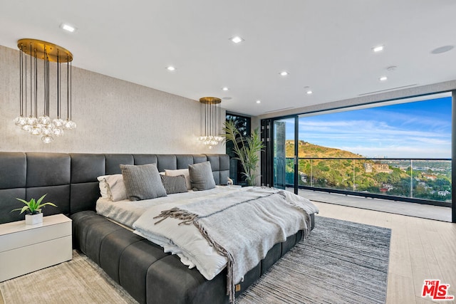 bedroom with light hardwood / wood-style floors and expansive windows