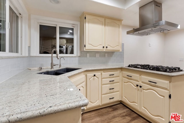 kitchen with range hood, decorative backsplash, gas cooktop, sink, and cream cabinetry