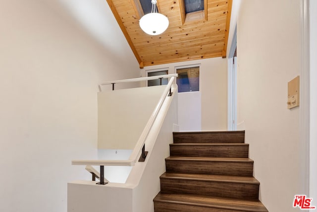 staircase featuring vaulted ceiling and wooden ceiling