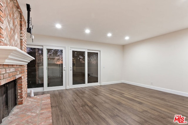 unfurnished living room featuring wood-type flooring and a fireplace