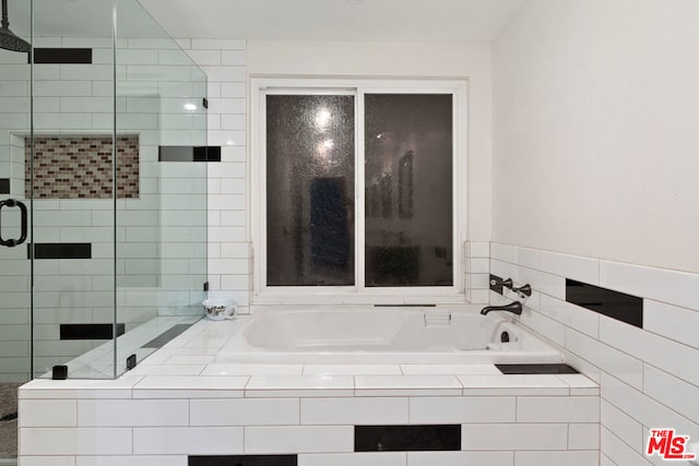 bathroom featuring separate shower and tub