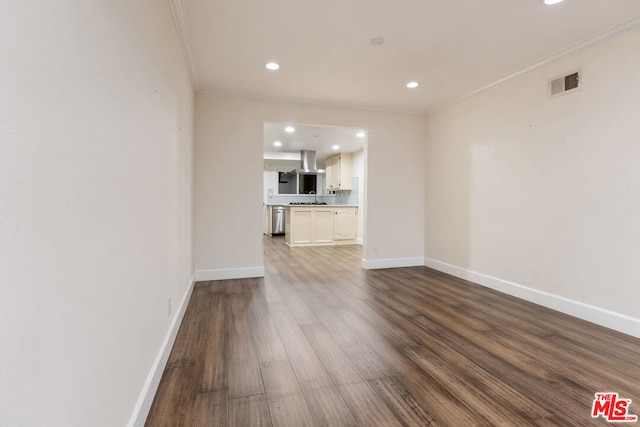 unfurnished living room featuring hardwood / wood-style flooring, sink, and crown molding