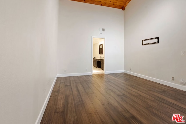 spare room featuring high vaulted ceiling, dark hardwood / wood-style floors, and wooden ceiling