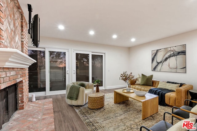 living room with wood-type flooring and a fireplace