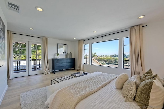 bedroom with access to exterior, light hardwood / wood-style floors, and french doors