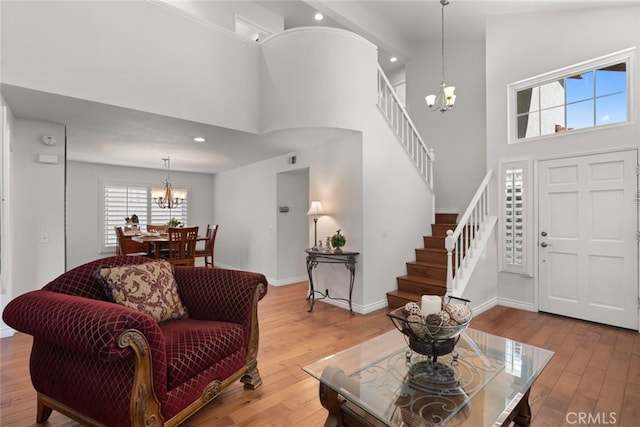 living room featuring a high ceiling, hardwood / wood-style floors, and an inviting chandelier