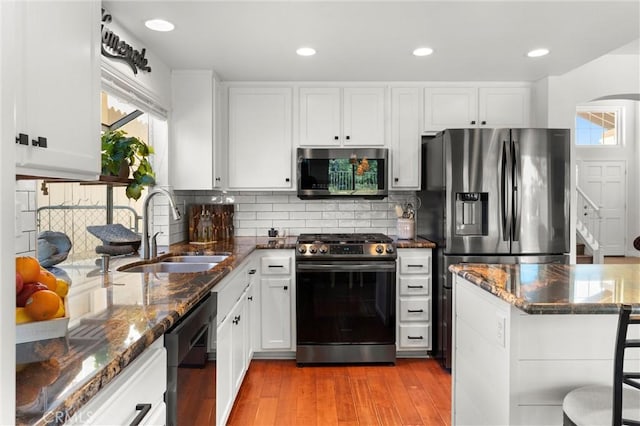 kitchen featuring sink, white cabinets, appliances with stainless steel finishes, and dark stone counters