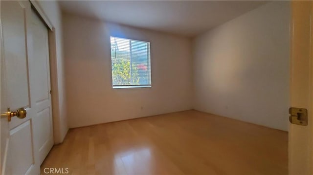 unfurnished bedroom with light hardwood / wood-style flooring and a closet