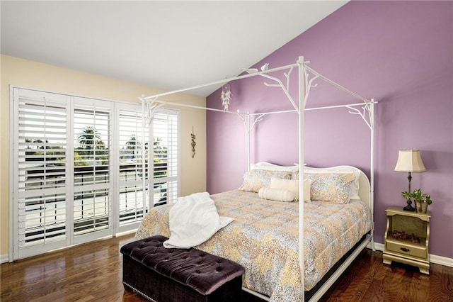 bedroom with vaulted ceiling and dark hardwood / wood-style flooring