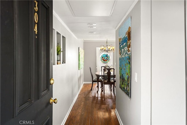 hall with dark hardwood / wood-style floors and a chandelier