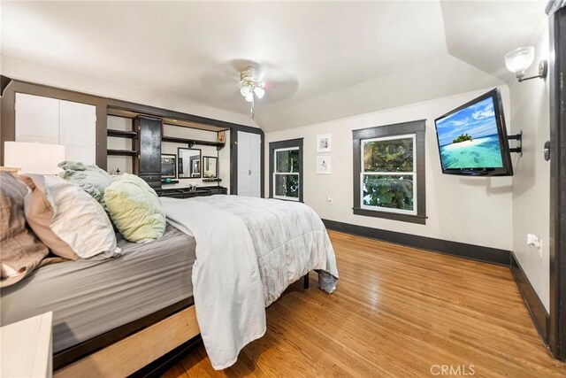 bedroom featuring ceiling fan, light wood-type flooring, and lofted ceiling