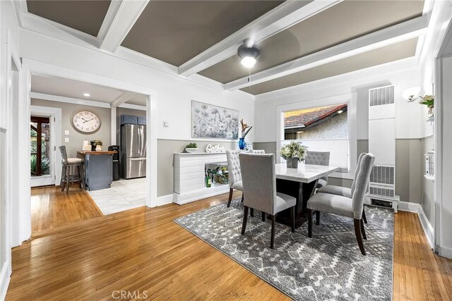 dining space featuring beamed ceiling and hardwood / wood-style flooring