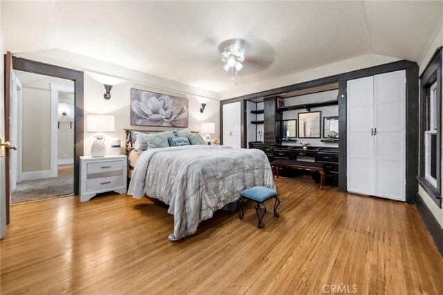 bedroom featuring ceiling fan, lofted ceiling, and light hardwood / wood-style flooring