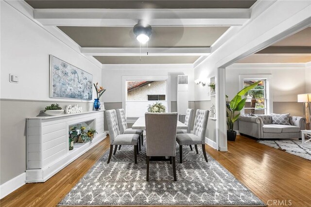 dining space with hardwood / wood-style floors and beamed ceiling