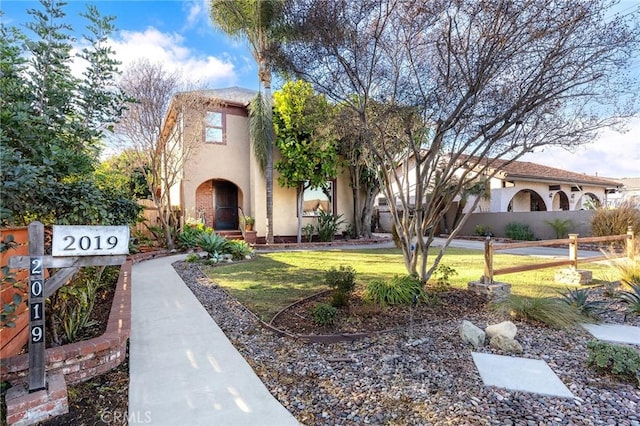 mediterranean / spanish-style house featuring a front yard