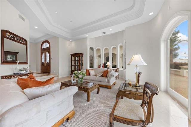 living room with a raised ceiling, a healthy amount of sunlight, light tile patterned flooring, and a high ceiling