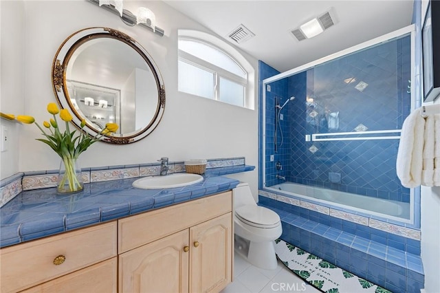 full bathroom with toilet, tiled shower / bath combo, tile patterned floors, and vanity