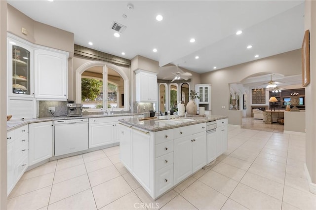 kitchen with white dishwasher, white cabinets, and a center island