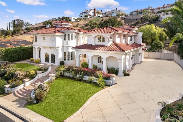 mediterranean / spanish-style home featuring a garage and a front yard