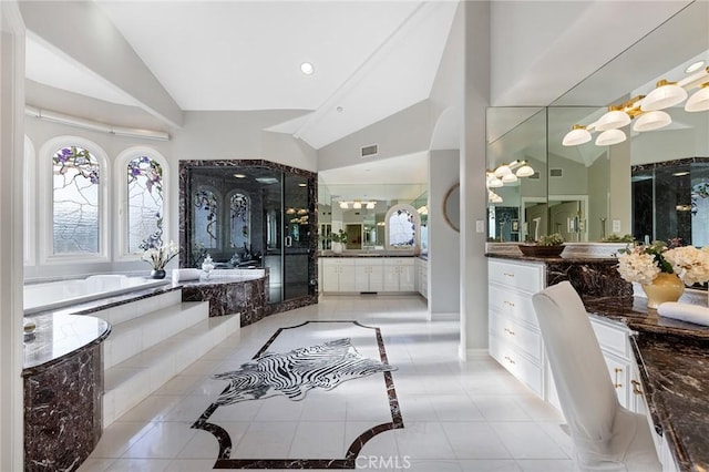 bathroom with tile patterned flooring, plus walk in shower, vanity, and vaulted ceiling