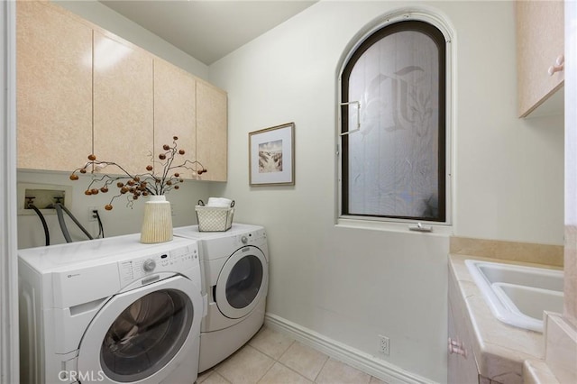 laundry room featuring washing machine and dryer, cabinets, light tile patterned flooring, and sink