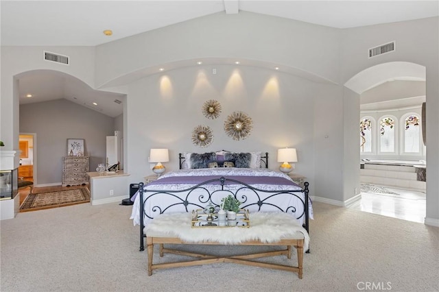 bedroom featuring lofted ceiling, a multi sided fireplace, connected bathroom, and carpet flooring