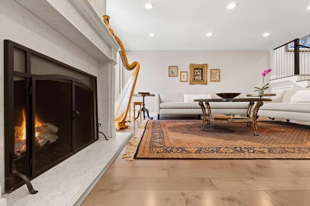 living room featuring a high end fireplace and light hardwood / wood-style floors