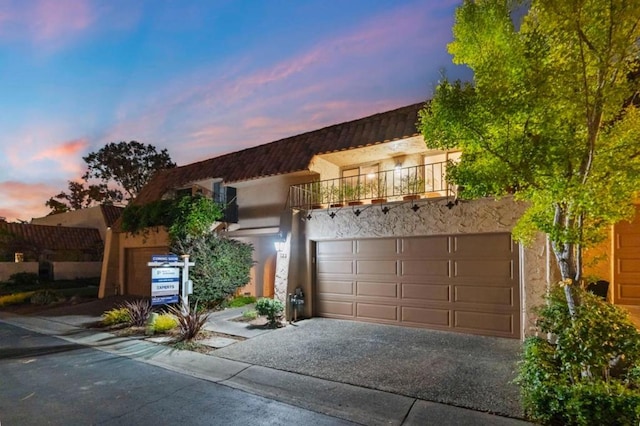 view of front of home with a garage and a balcony