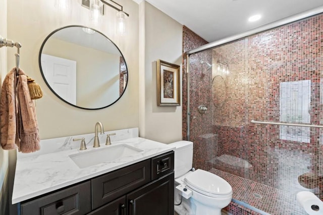 bathroom with walk in shower, vanity, and toilet