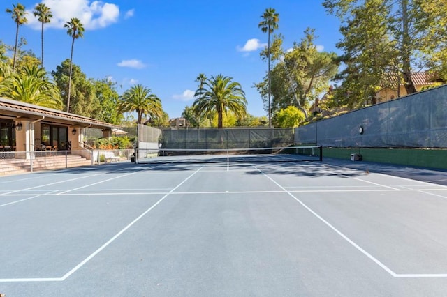 view of tennis court with basketball hoop