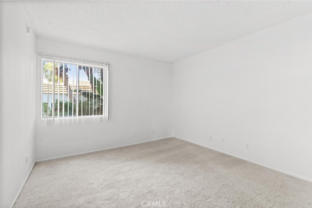 carpeted spare room with a textured ceiling