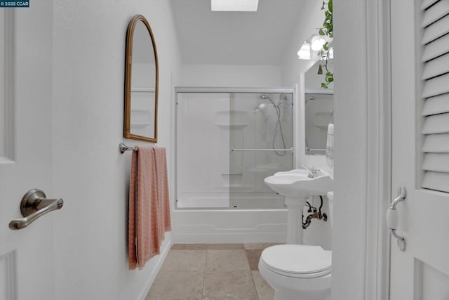 bathroom with combined bath / shower with glass door, toilet, and tile patterned flooring