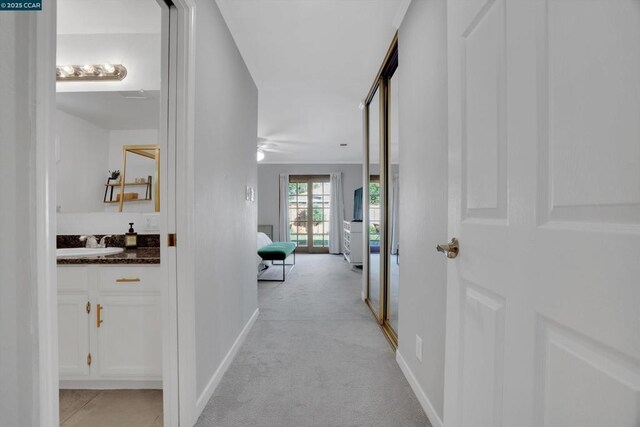 corridor with light carpet and sink