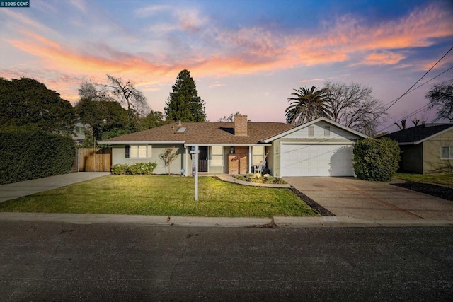 ranch-style house featuring a garage and a yard