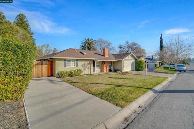 ranch-style house featuring a front lawn and a garage