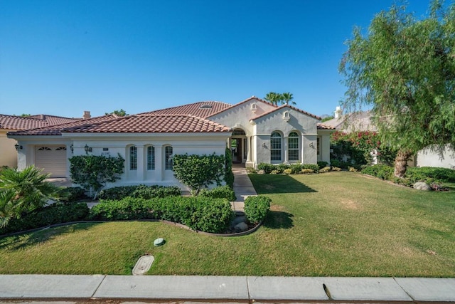 mediterranean / spanish home with a garage and a front yard