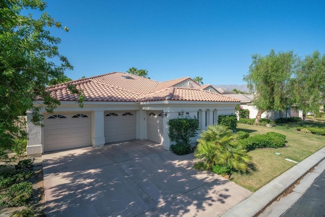 mediterranean / spanish home featuring a front lawn and a garage