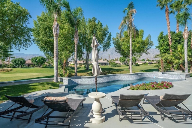 view of pool featuring a patio, a mountain view, and a lawn