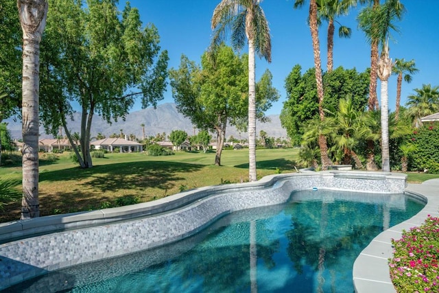 view of swimming pool featuring a mountain view and a lawn