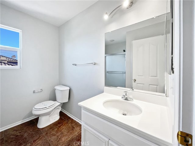 bathroom with toilet, vanity, tile patterned floors, and a shower with shower door