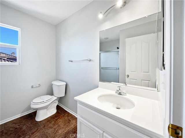 bathroom with toilet, vanity, tile patterned floors, and a shower with shower door