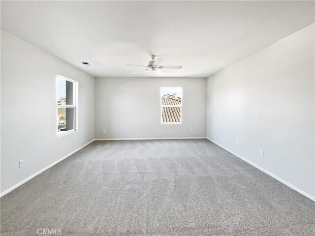 carpeted spare room featuring ceiling fan