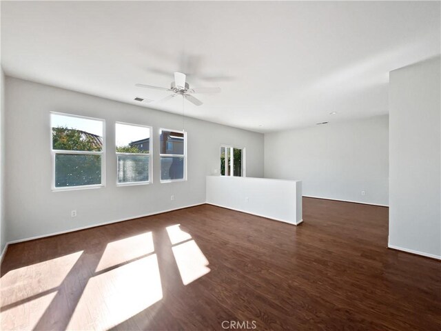 empty room with ceiling fan and dark hardwood / wood-style flooring