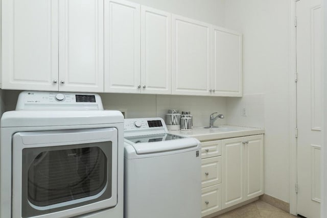 laundry room featuring cabinets, sink, light tile patterned floors, and washer and clothes dryer